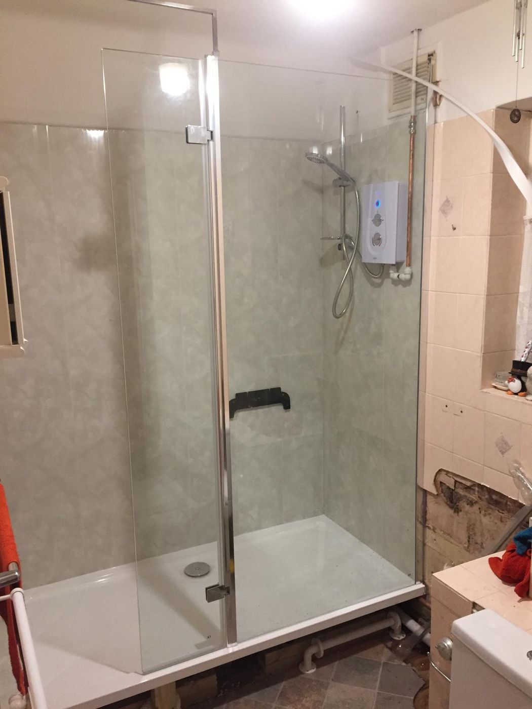 Finished walk-in shower with a glass screen in the same corner