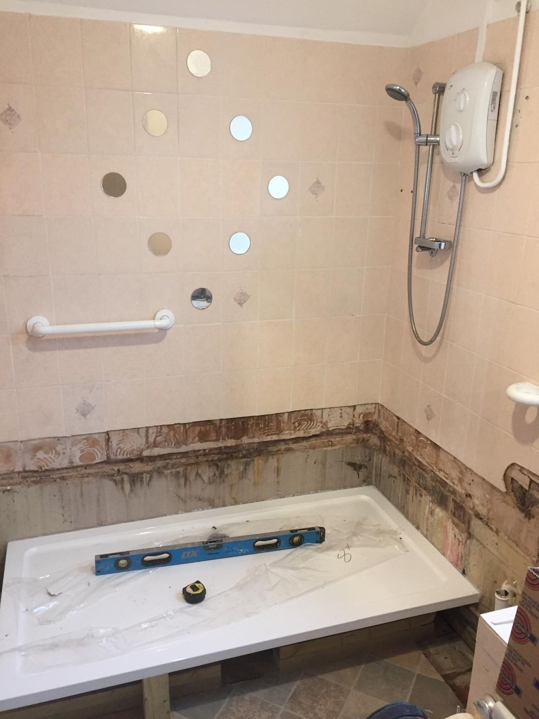 Bath removed and the new shower tray being levelled into place