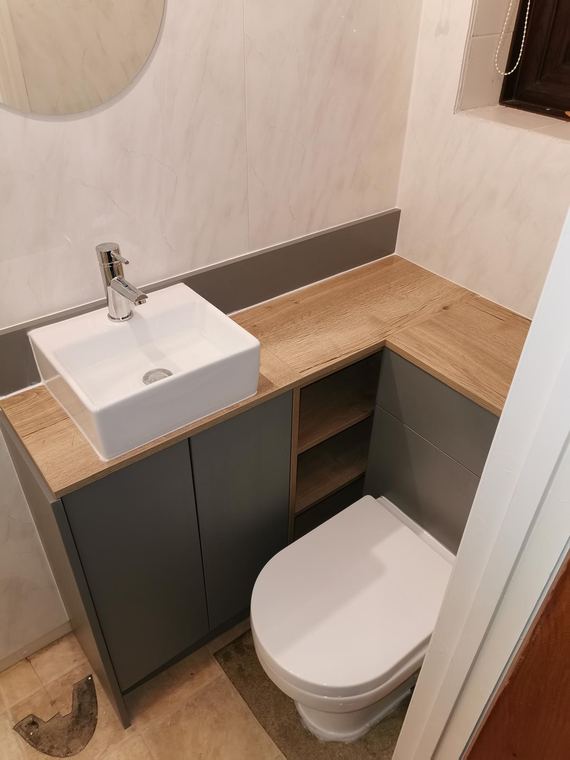 Basin set on a timber shelf above a wall-hung toilet