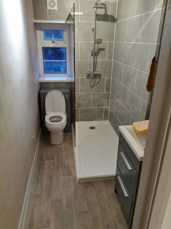 Compact shower room with a vanity unit and wood-effect floor