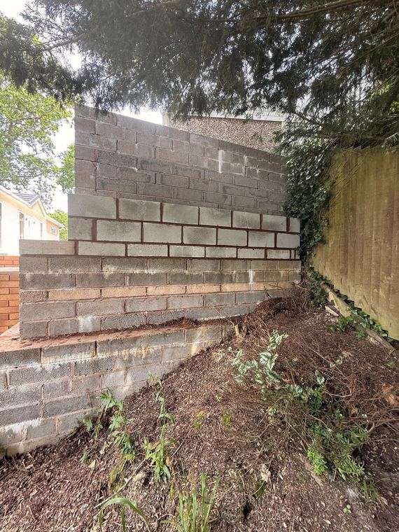 Block and brick wall holding back a bank