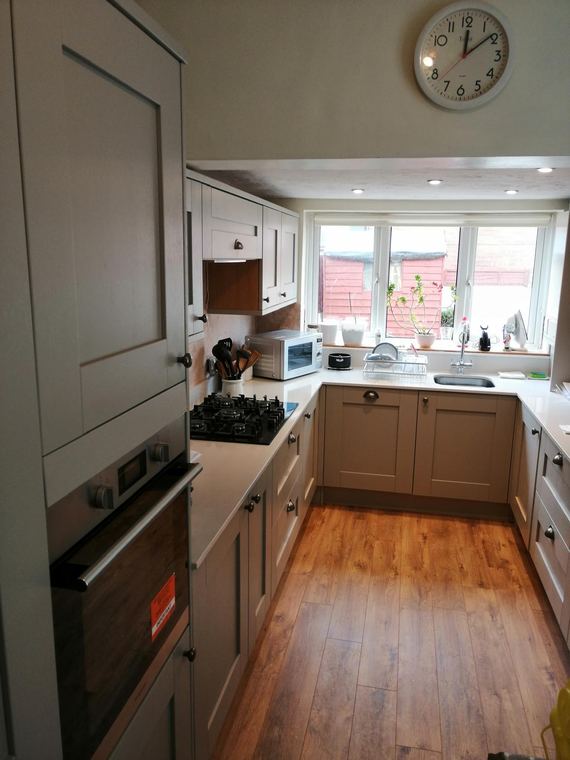 Galley kitchen finished with a wood floor and bay window