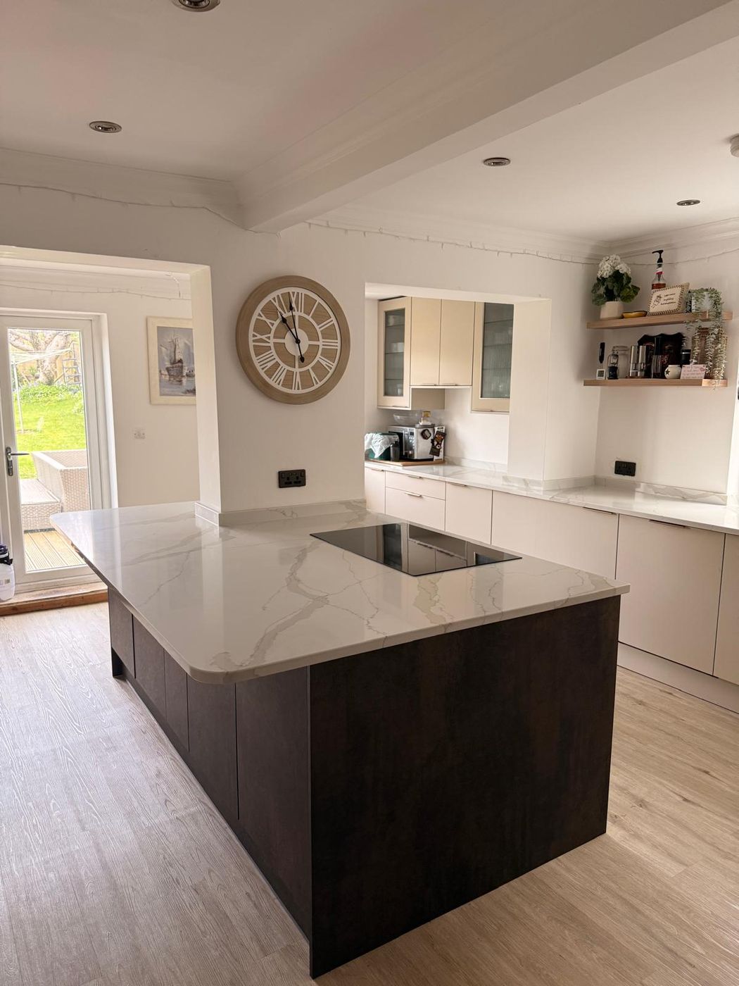 The same kitchen rebuilt with a large quartz-topped island