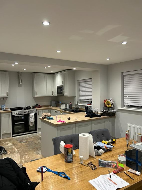 Pale shaker kitchen with a wood worktop and peninsula