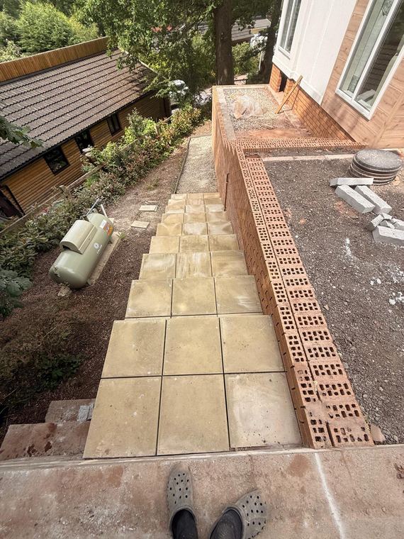 Paving slabs being laid with a brick edging detail