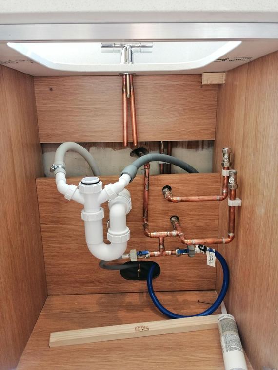 Copper supply and waste pipework set out under a sink