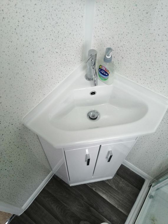 Corner basin and vanity in a compact shower room