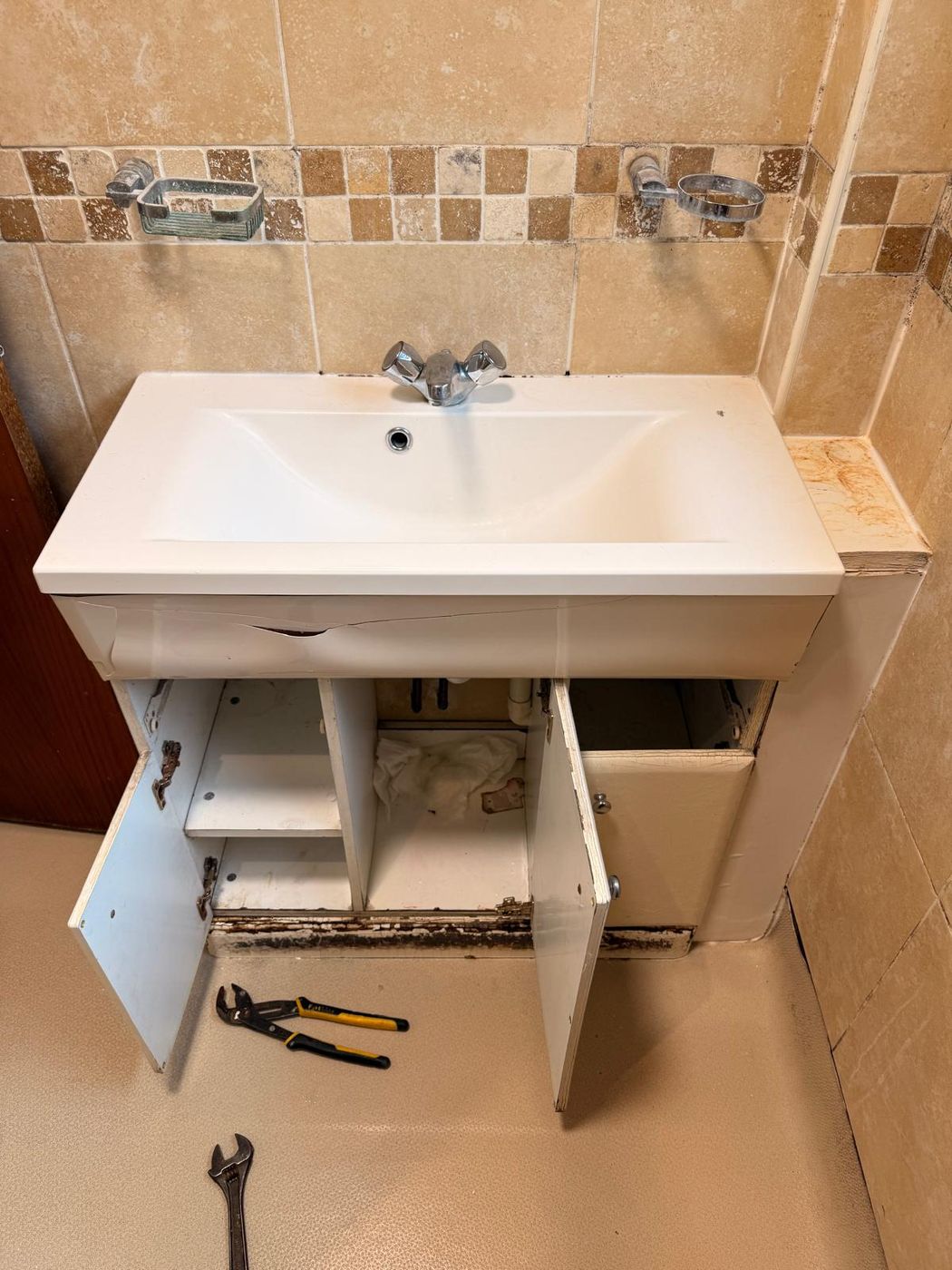 Old basin unit opened up, showing water damage inside the carcass