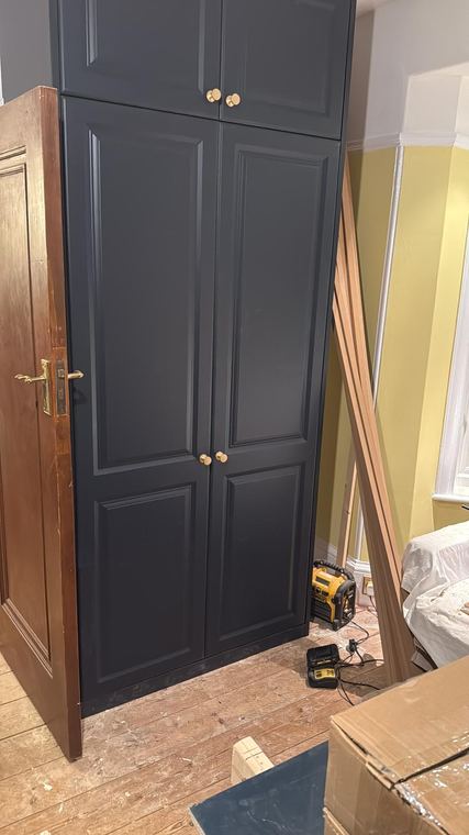 Fitted wardrobes built into an alcove and painted navy